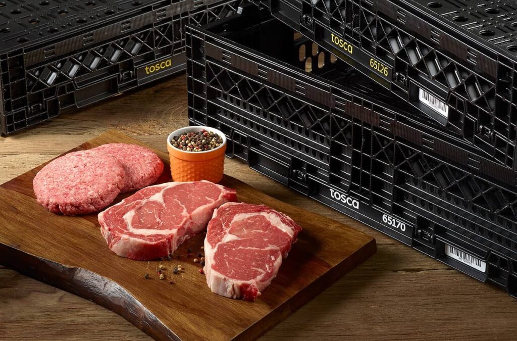 Steak and burgers on a cutting board with crates