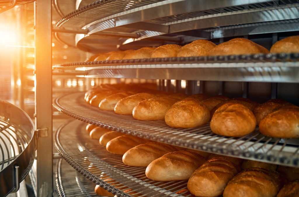 A lot of bread prepare to move on in the shelf. Bread bakery food factory production with fresh products. Automated production of bakery products.