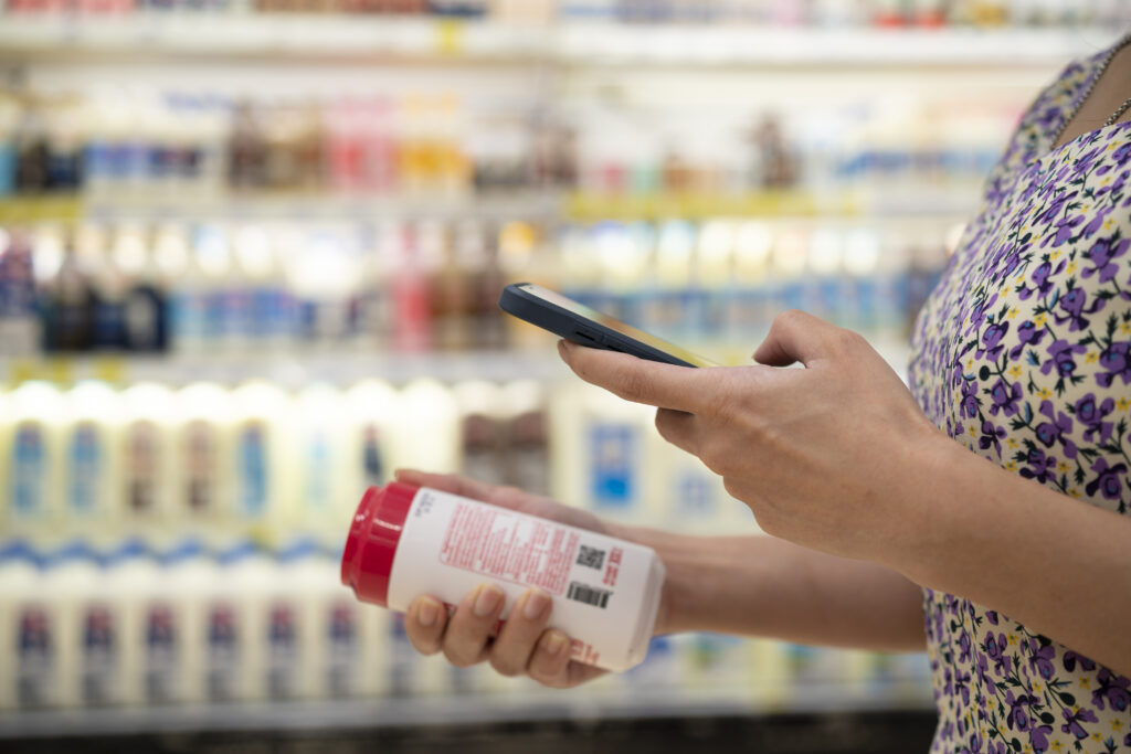 close up of asian young businesswoman is shopping for meat and scanning barcode